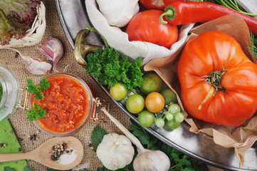 Fototapeta na wymiar Tomato sauce and ingredients for its cooking on metal dish. Horizontal.