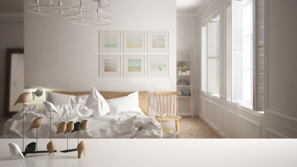 Fototapeta na wymiar White table top or shelf with minimalistic bird ornament, birdie knick - knack over blurred scandinavian white bedroom, modern interior design