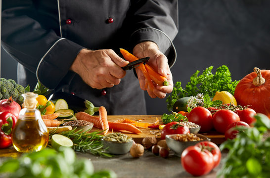 Man peeling carrot over wooden cutting board - Powered by Adobe