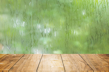blur fresh wet moist green nature with wooden table foreground space for products decoration...
