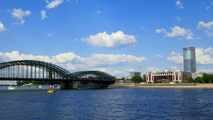 Naklejka premium Rhein bei Köln mit Hohenzollernbrücke und Aussichtsturm Triangle vor malerischem Himmel