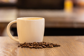 cup of coffee and beans on wooden table