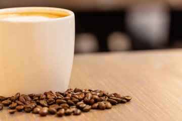 cup of coffee and beans on wooden table