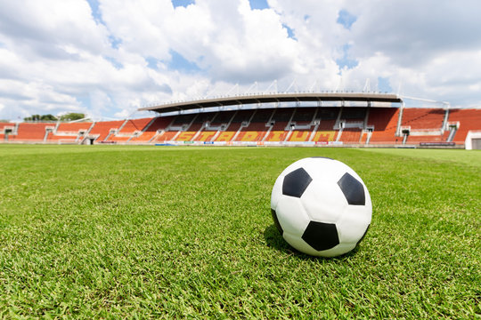 football field - ball on green grass , soccer field athletics stadium and blue sky background