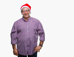 Handsome senior man wearing christmas hat over isolated background with a happy and cool smile on face. Lucky person.