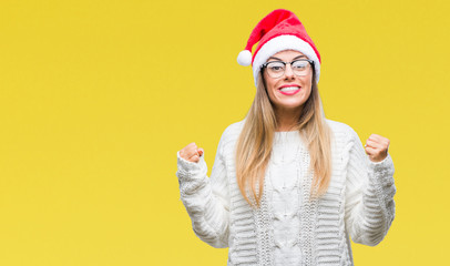 Young beautiful woman wearing christmas hat over isolated background celebrating surprised and amazed for success with arms raised and open eyes. Winner concept.