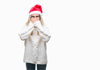 Young beautiful blonde woman wearing christmas hat over isolated background shocked covering mouth with hands for mistake. Secret concept.