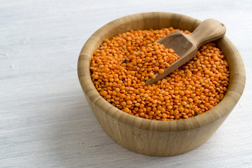Red dry lentils in a bamboo bowl.