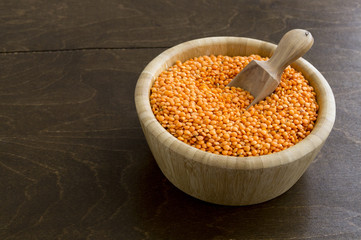 Red dry lentils in a bamboo bowl.
