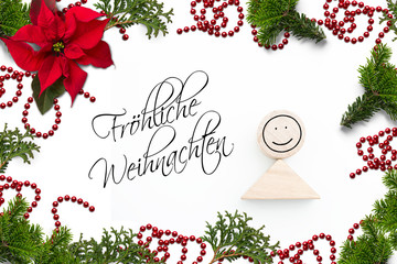 Weihnachtsdekoration und Gruß "Fröhliche Weihnachten" auf weißem Hintergrund