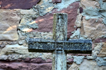 Kreuz vor Natursteinmauer
