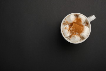 Hot coffee with marshmallow top view on black background with copy space. Winter beverage concept