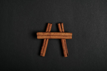 cinnamon sticks on black background top view