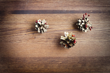 Christmas decoration, fir cones on wood background top view