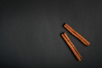 cinnamon sticks on black background top view with copy space for text