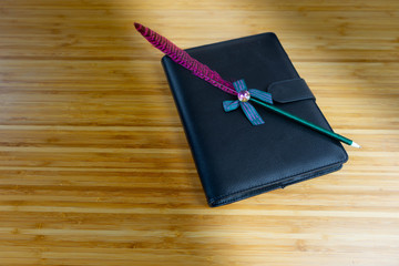 Hand writing books wallet and notebook placed on a wooden table. top view image of open notebook with blank pages next to cup of coffee on wooden table. Notepad with pencil on the wood background.