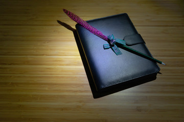 Hand writing books wallet and notebook placed on a wooden table. top view image of open notebook with blank pages next to cup of coffee on wooden table. Notepad with pencil on the wood background.