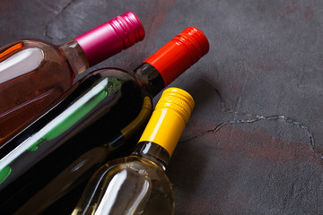 Bottles of red white and pink rose wine on stone kitchen table background. Top view. Space for text