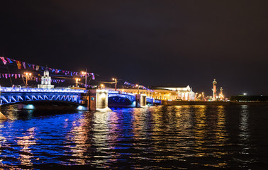 Fototapeta na wymiar Brightly lit Palace Bridge and the Spit of Vasilyevsky Island at night in St. Petersburg. Russia