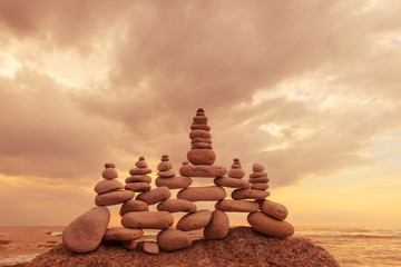 Large, openwork pyramid made of white balanced stones on the edge of the rock