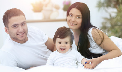 Obraz premium Cheerful family having fun together lying on a bed
