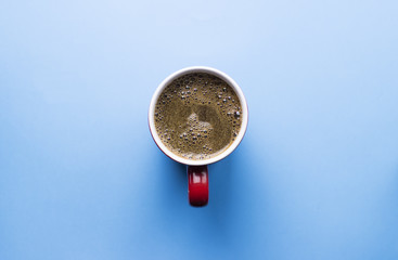 Coffee cup from top on blue background. Space for text