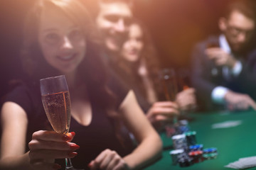 fashion woman with glasses of wine,sitting at a table in a casino