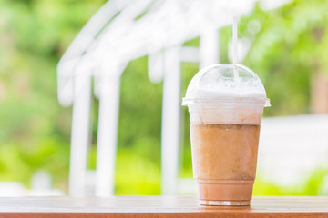 Ice cappuccino coffee on wooden table top on bokeh background for display or montage abstract or product.