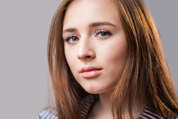 Naklejka premium Close up face of a beautiful young girl with a clean skin