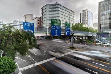Fototapeta premium Blurred cars are passing through junction in Downtown Nagoya, Japan