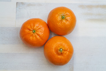 Group of three mandarines on wooden background