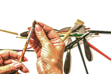 Golden hands of the artist choosing a brush