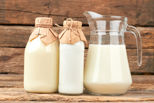 Organic cow milk in glass dishes. Vintage style bottles with milk and sour cream. Natural milk for health.