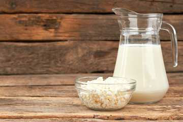Jug of milk and cottage cheese. Healthy dairy products on rustic wooden background with copy space.