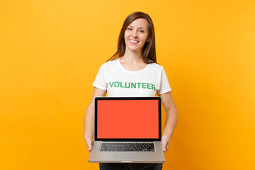 Woman in white t-shirt written inscription green title volunteer hold laptop pc computer, blank...