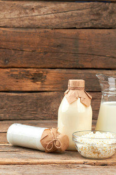 Eco milk products on wooden background. Healthy dairy ingredients including fresh milk, sour cream and cottage cheese. Traditional dairy background.