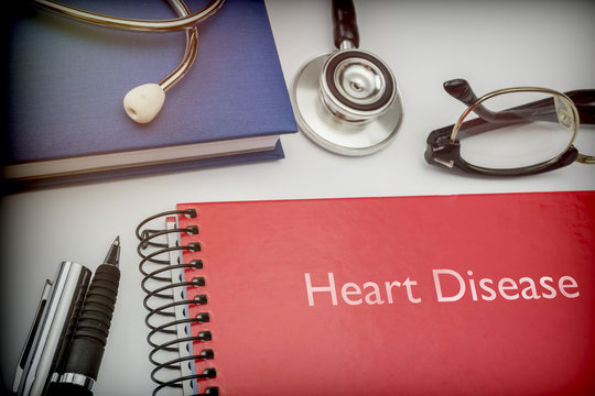  Titled red book Heart Disease along with medical equipment, conceptual image
