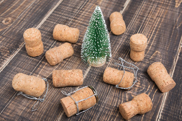 minimal christmas concept, decorative Christmas tree on old boards, around scattered cork from champagne, holiday idea