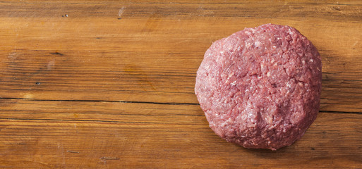 raw minced meat on wooden background - top view