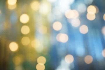 Obraz premium Bokeh from indoor lighting, Colorful light circles spread on blue with yellow and green background for the celebration of the holiday season