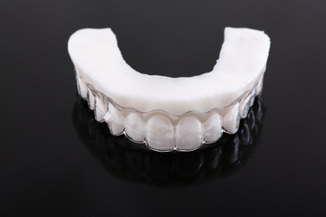 Wax pattern teeth dental crowns on model, metal free - front view .Ceramic front veneers isolated on black background. Metal-Ceramic crowns on gypsum model in dental laboratory.