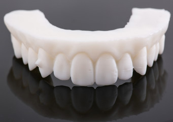Wax pattern teeth dental crowns on model, metal free - front view .Ceramic front veneers isolated on black background. Metal-Ceramic crowns on gypsum model in dental laboratory.