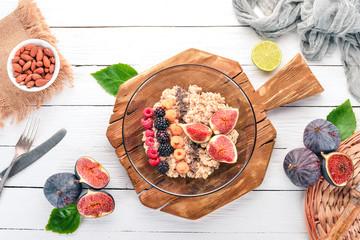 Oatmeal porridge with figs, raspberries, blackberries and chia seeds. Healthy food. Free space for text. Top view.