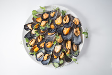 Lots of mussels with green on the plate