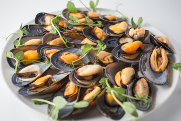 Lots of mussels with green on the plate