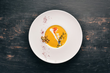 Pumpkin soup with seeds. Healthy food. On a wooden background. Free copy space. Top view.