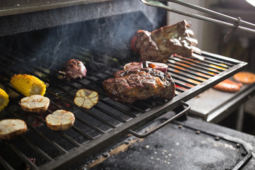 Vegetables and meat on the grill on hot coals with smoke