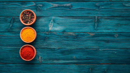 Spices and herbs on a blue wooden table. Basil, pepper, saffron, spices. Indian traditional cuisine. Top view. Free copy space.