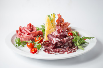 Set of italian sausages with green, tomatoes, chili and arugula