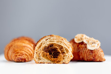  Fresh croissant with caramel and banana toppings on bright  background. Macro